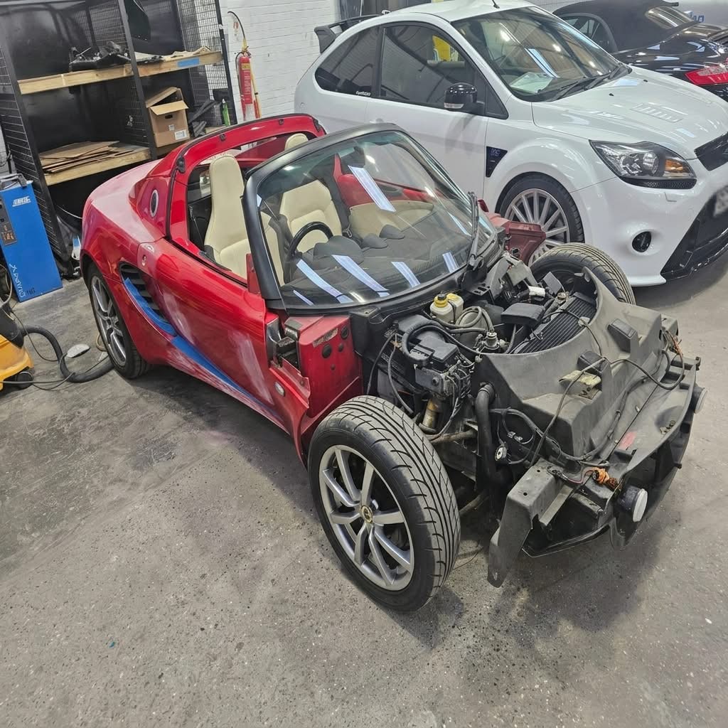 Red convertible with body panels removed during repair preparation at our East Kilbride partner coachworks