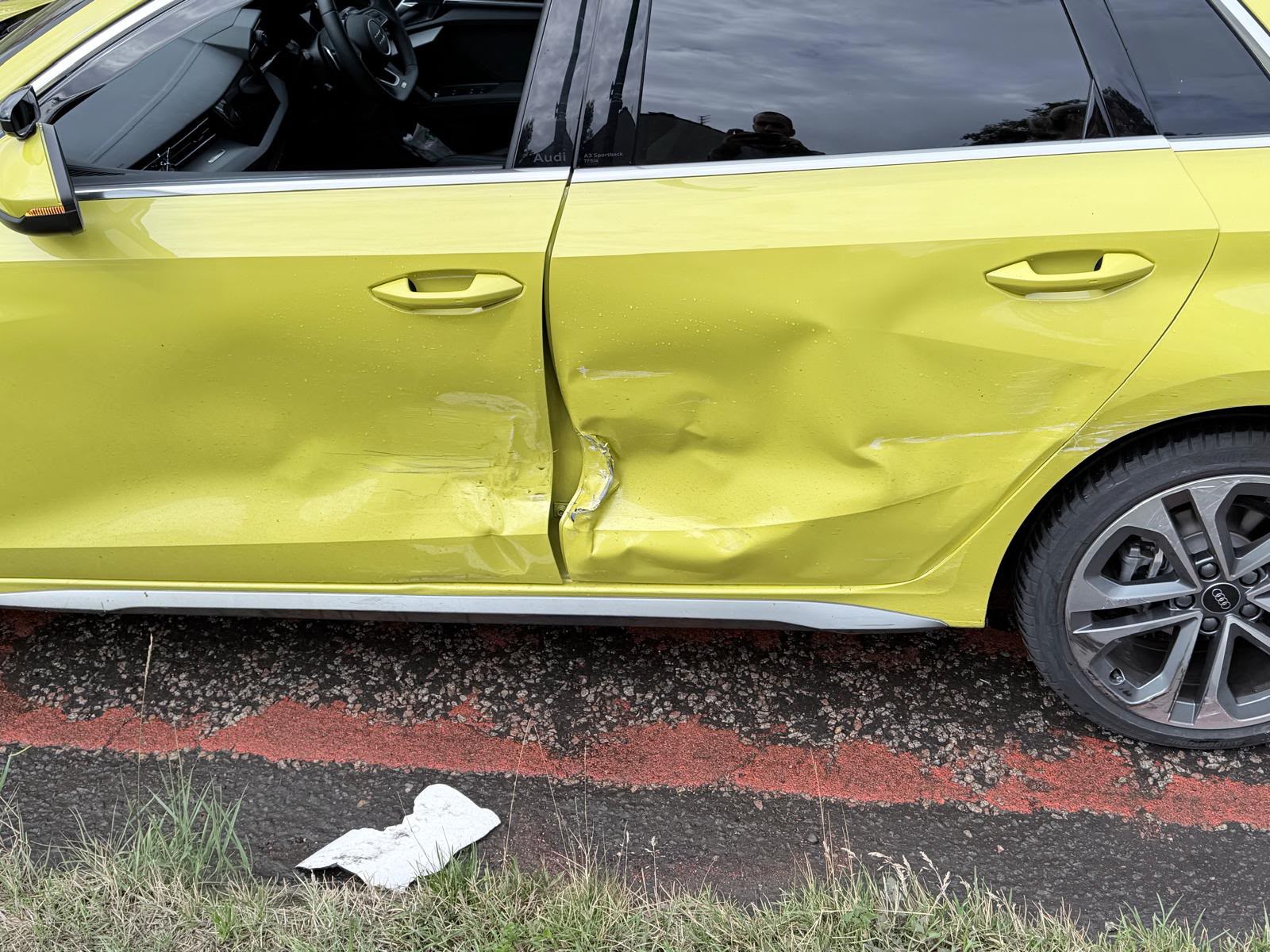 Damaged nearside doors and rear quarter of a yellow Audi A3 before repair